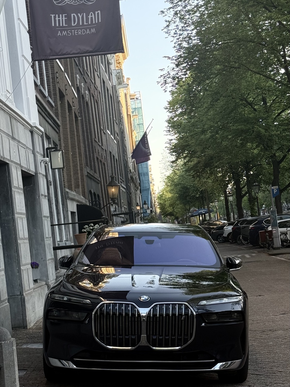 Black BMW chauffeur car waiting outside an Amsterdam hotel before an intercity drive