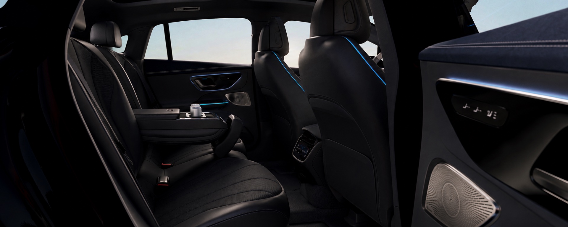 Rear cabin of an AmstelCab Mercedes-Benz EQE in black leather with blue ambient light — the Business Class seat for chauffeured rides in Leiden
