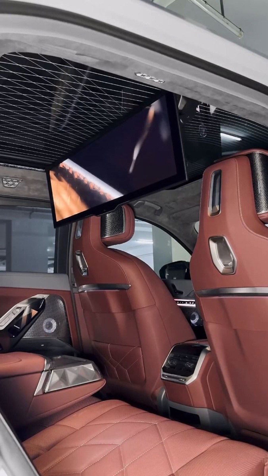 The i7’s rear seats in quilted cognac leather, seen from the kerbside door in a garage